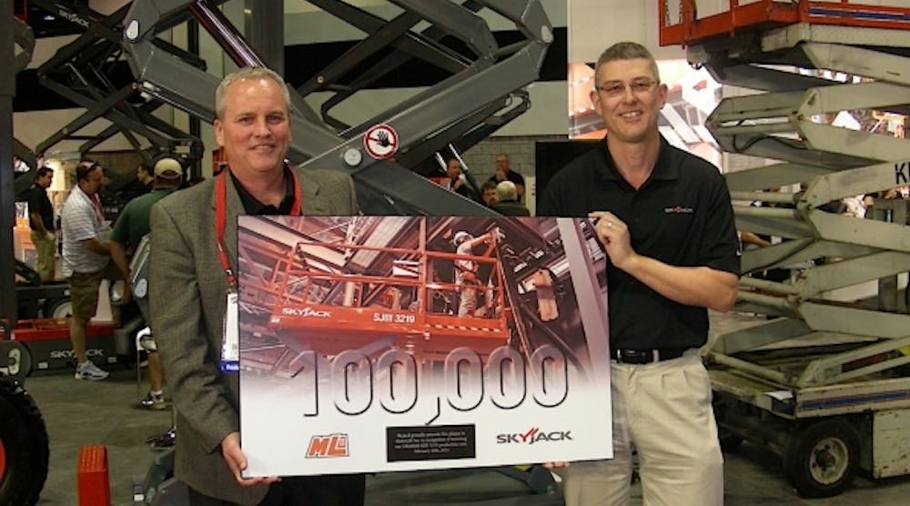 Rick Dahl, left, of Metrolift, is honored for buying the 100,000th SJIII 3219 scissorlift manufactured by Skyjack. At right is Skyjack president Brad Boehler. (Photo by Michael Roth, RER)