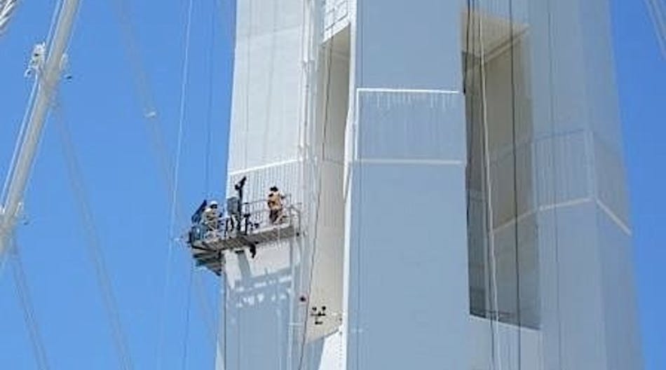 Workers work on the 525-foot tall tower of the San Francisco-Oakland Bay Bridge in a custom platform designed by Spider engineers.