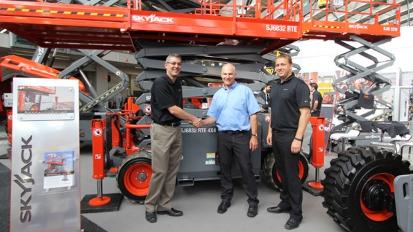 Brad Boehler left Skyjack president prepares to hand over a new SJ 6832 RTE to SkyAccess managing director Martin Vogtli At right is Skyjack European sales director Ron Scheurs