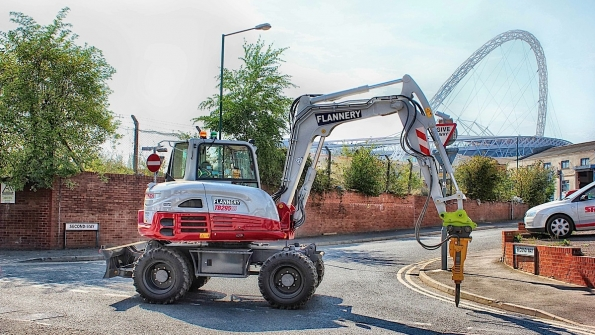An Atlas Copco SB302 mounted on a Takeuchi TB295W works on a UK street