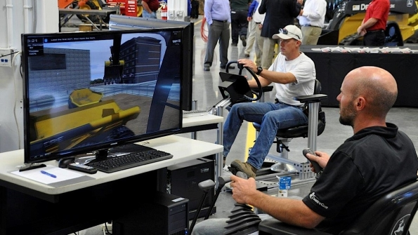 Open house attendees try their hands at a Deere excavator simulator that creates a realistic experience for operators in a riskfree environment