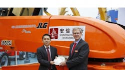 Jiayin Wang, president of Shanghai Horizon Equipment &amp; Engineering Co., celebrates his company&rsquo;s purchase with a commemorative plate offered by JLG Industries president Frank Nerenhausen.