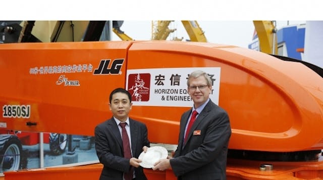 Jiayin Wang, president of Shanghai Horizon Equipment &amp; Engineering Co., celebrates his company&rsquo;s purchase with a commemorative plate offered by JLG Industries president Frank Nerenhausen.