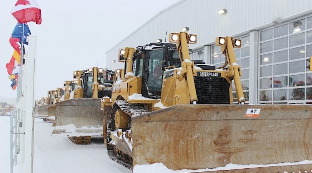 Earthmoving machinery crosses the stage at Edmonton auction.
