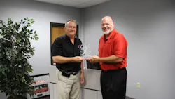 Takeuchi US president Clay Eubanks presents a plaque to David Pearson left inside sales manager in honor of 30 years with the company Takeuchi US president Clay Eubanks presents a plaque to David Pearson left inside sales manager in honor of 30 years with the company