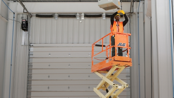 A JLG electric scissors at work in an industrial facility