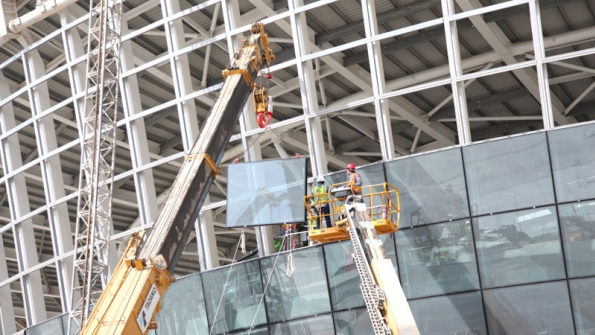 Workers use a Haulotte boomlift for glass installation at Abu Dhabi airport