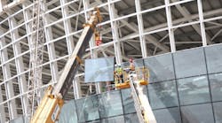 Workers use a Haulotte boomlift for glass installation at Abu Dhabi airport.