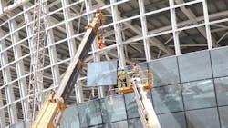 Workers use a Haulotte boomlift for glass installation at Abu Dhabi airport Workers use a Haulotte boomlift for glass installation at Abu Dhabi airport
