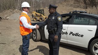 A contractor thanks a police officer for helping to recover stolen equipment.