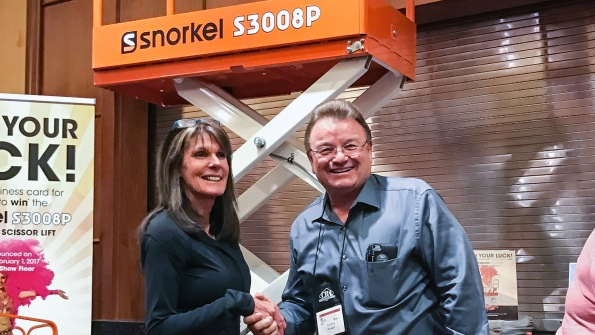 Lynne Domey of Eastern Oregon Sales amp Rentals takes home a Snorkel S3008P scissorlift and is congratulated by Snorkel owner Don Ahern