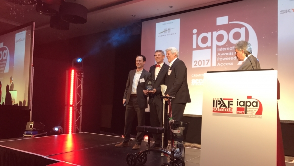 Wade Carson left and Jim Colvin right accept the award from Brad Boehler President of Skyjack At right is BBC sports broadcaster John Inverdale