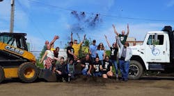 Volunteers toss soil in the air to celebrate the planting of 514 food-growing gardens. The initiative promotes a sustainable food system by building communities of people who grow their own food, and provides educational programs and urban agricultural projects.