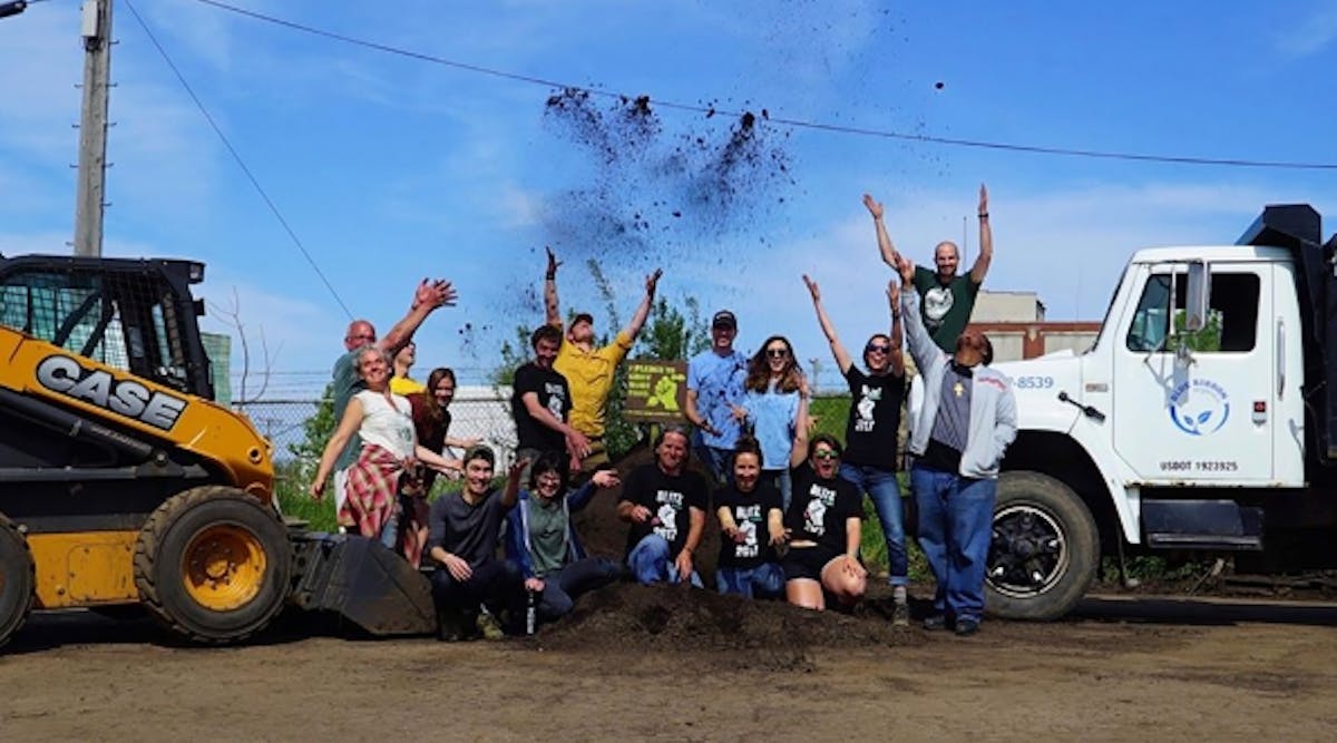 Volunteers toss soil in the air to celebrate the planting of 514 food-growing gardens. The initiative promotes a sustainable food system by building communities of people who grow their own food, and provides educational programs and urban agricultural projects.