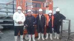 Workers at the Avicola Sofia plant in La Paz, Bolivia, with their new Snorkel S3219E scissorlift, inside a refrigerated storage unit.