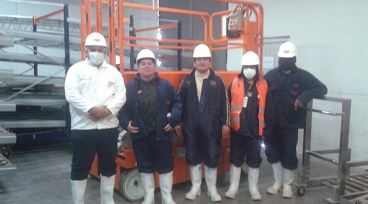 Workers at the Avicola Sofia plant in La Paz, Bolivia, with their new Snorkel S3219E scissorlift, inside a refrigerated storage unit.