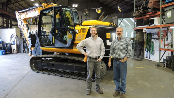 From left Norlift JCB sales manager Nate Jarvis and owner Jay Jarvis with the first sold JCB machine a JS145 excavator