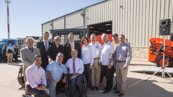 Kubota governor Greg Abbott seated in center thanks Kubota staff for the contribution which included money and skidsteer loaders