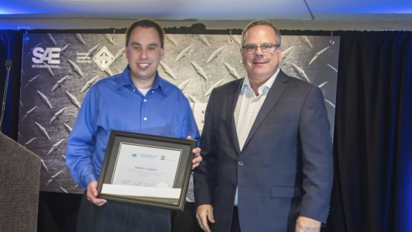 SAEAEM Outstanding Young Engineer Award winner Stephen Lanahan left received award from SAE board of directors commercial vehicle vice president Landon Sproull of PACCAR Inc at recent ceremonies