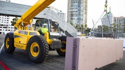 A Gehl telehandler moving a concrete block in Long Beach preparing the race track A Gehl telehandler moving a concrete block in Long Beach preparing the race track