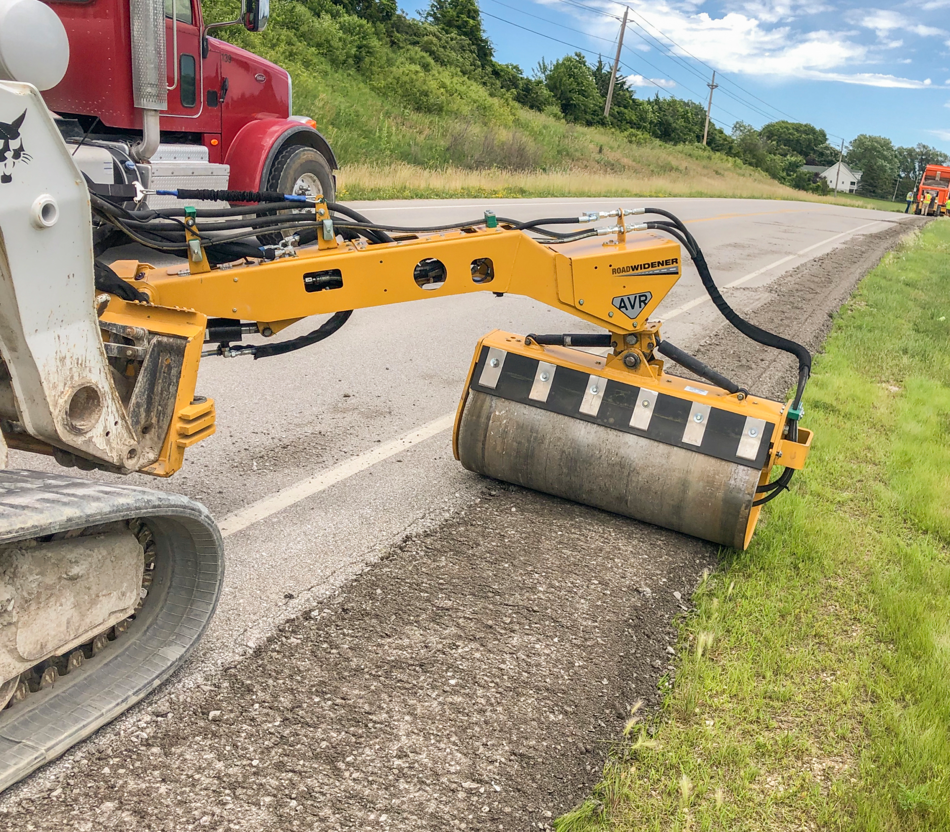 Road Widener offset vibratory roller spray bar system