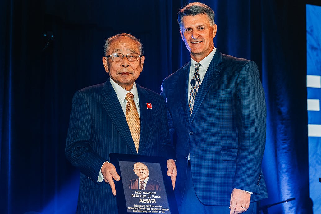 Akio Takeuchi poses with his award and 2023 AEM Chair Rod Schrader of Komatsu at the 2023 AEM Hall of Fame reception.