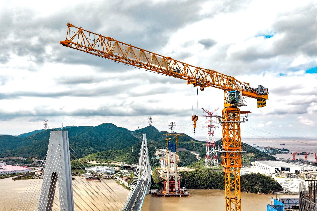 A Potain topless tower crane stands tall over the construction of China&rsquo;s Zhoushan Taoyaomen Bridge.