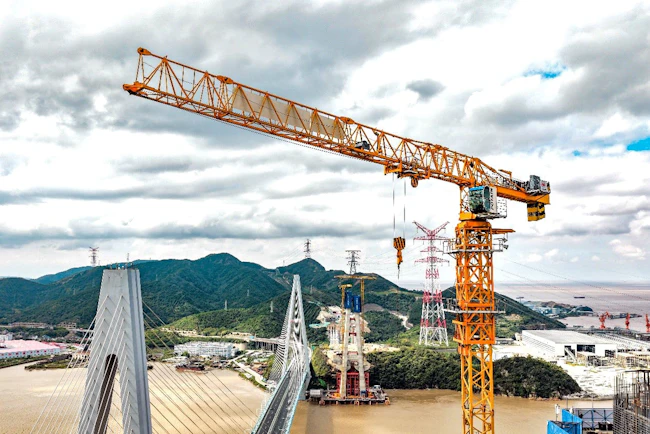 A Potain topless tower crane stands tall over the construction of China&rsquo;s Zhoushan Taoyaomen Bridge.
