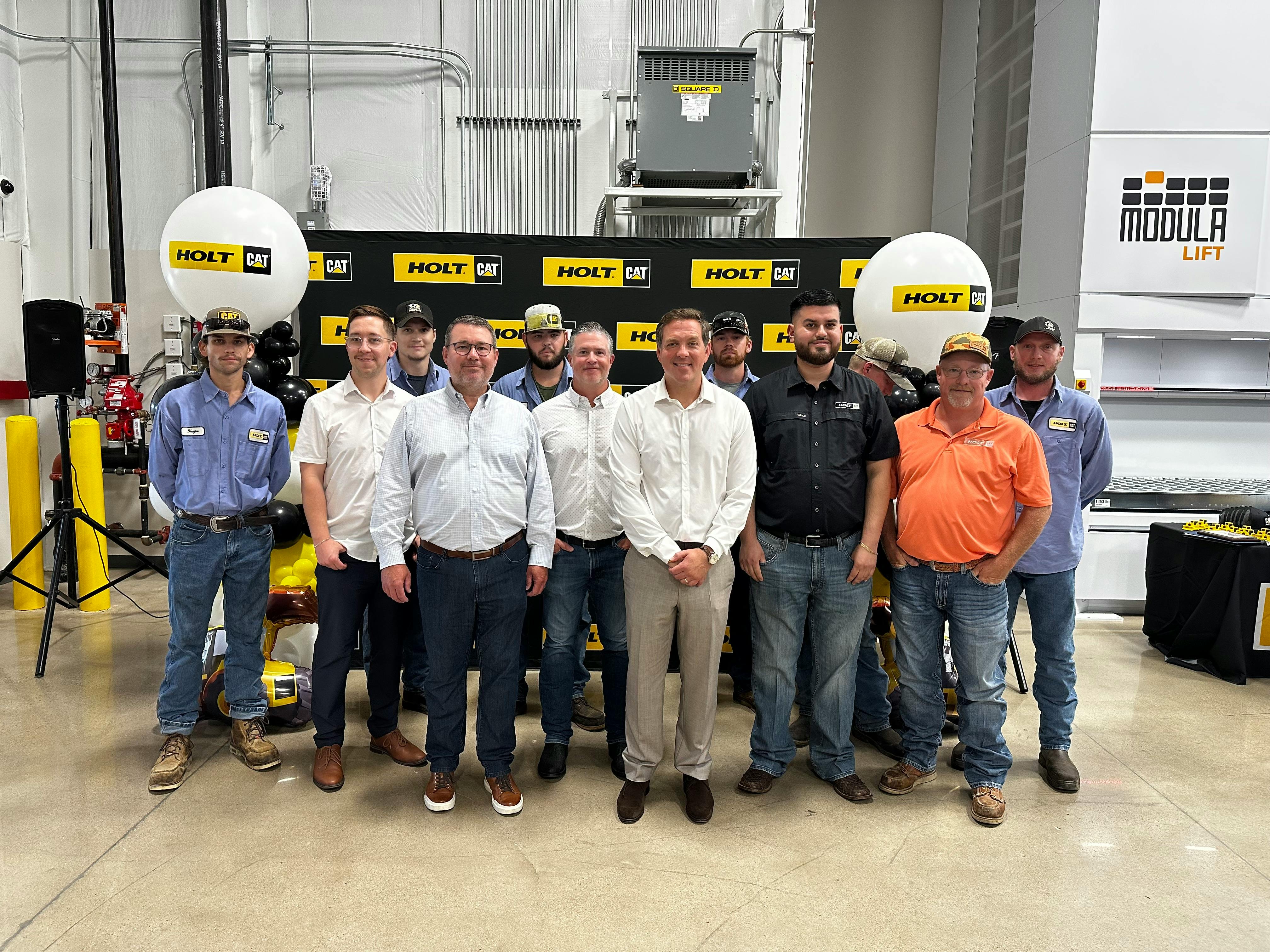 Peter Holt (beige pants, white shirt) joins staffers at Holt Cat's new Waxahachie, Texas, facility.