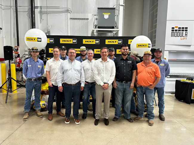 Peter Holt (beige pants, white shirt) joins staffers at Holt Cat's new Waxahachie, Texas, facility.